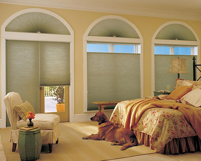 Cordless light filtering honeycomb cellular shade in neutral tone filtering soft daylight on large window