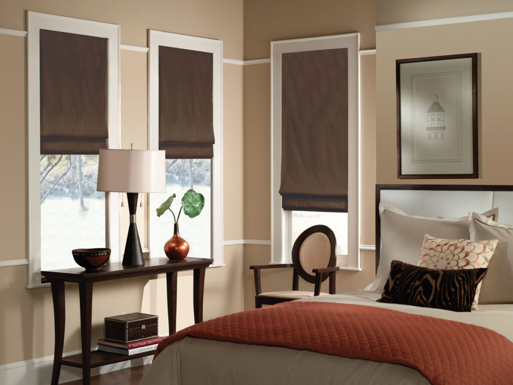 Custom flat fold roman shades in blackout fabric on bedroom windows showing smooth tailored finish