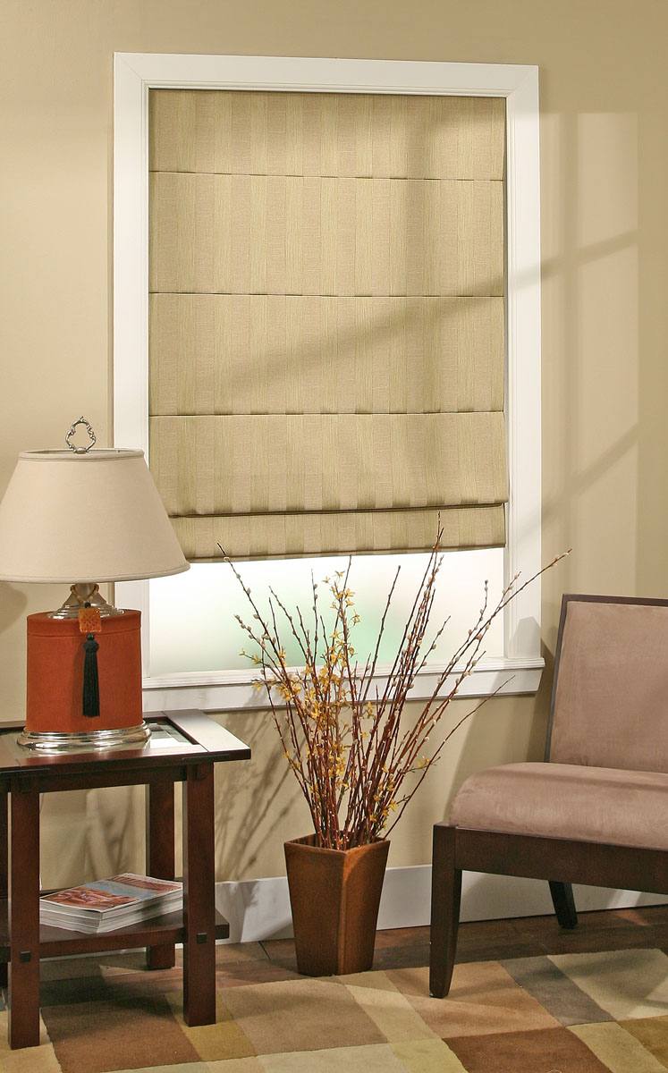 Custom plain roman shades in neutral linen fabric installed on living room windows with structured stay pocket pleats