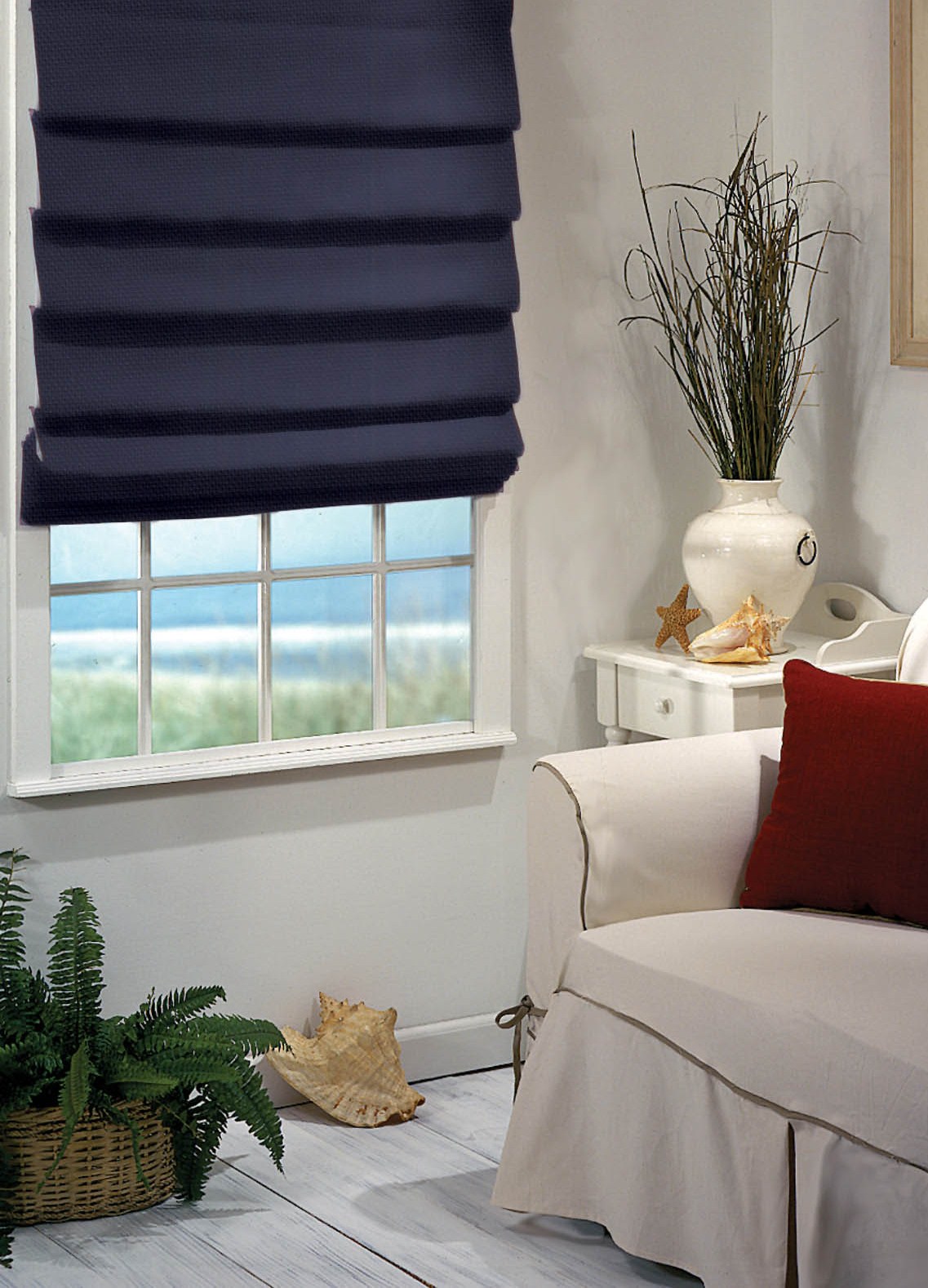 Custom soft fold roman shades in neutral fabric on living room window showing cascading hobbled folds at six inch intervals