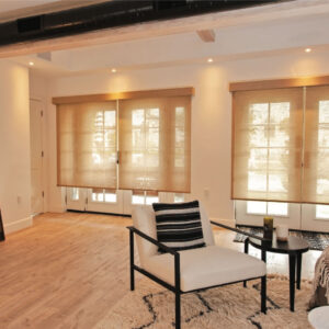 Perfect light filtering sheer and natural roller shades in warm tone installed on living room windows