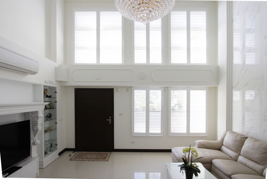 Faux Wood Shutters Plus in Pure White installed on living room window with open louvers