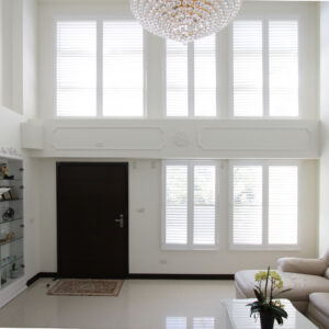 Faux Wood Shutters Plus in Pure White installed on living room window with open louvers
