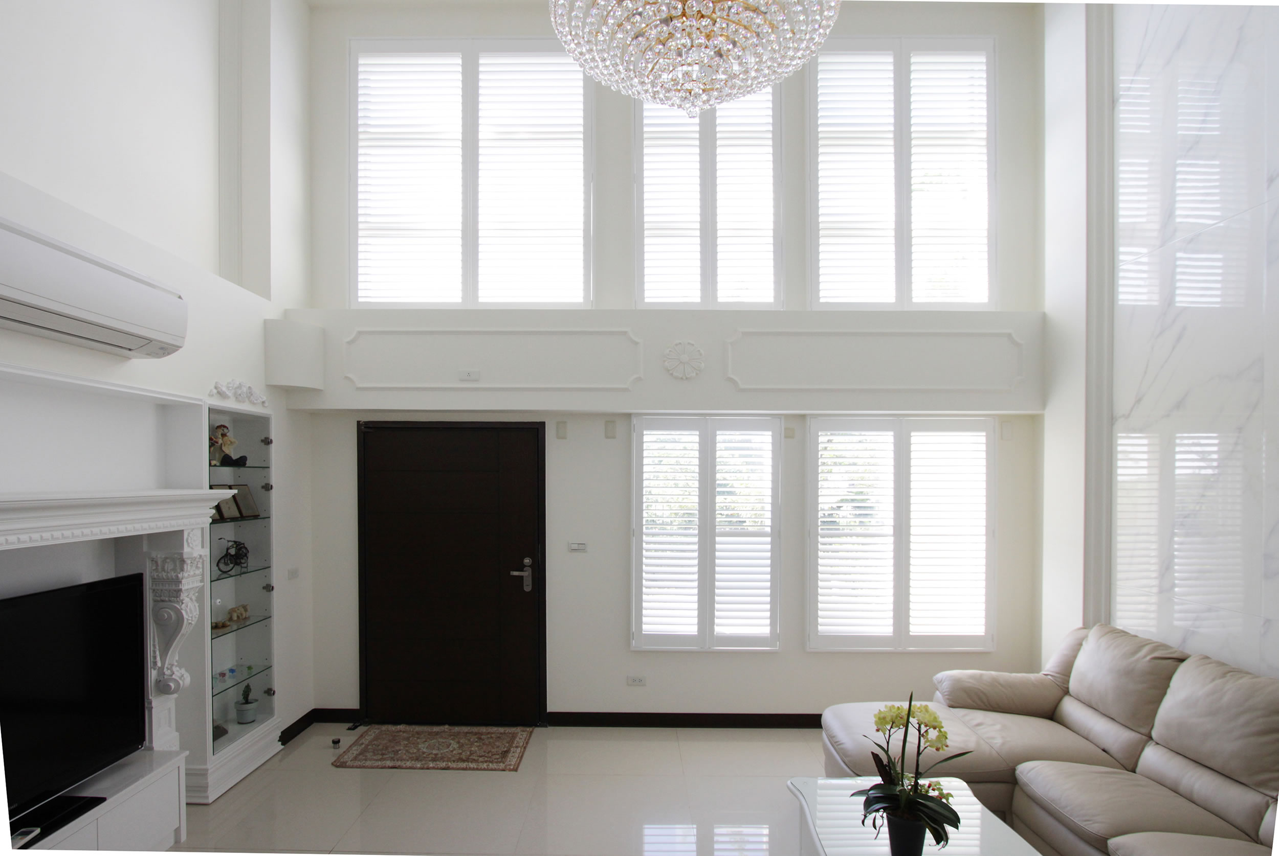 Faux Wood Shutters Plus in Pure White installed on living room window with open louvers